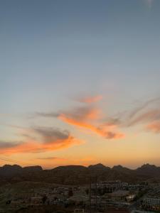 a view of a city with a cloudy sky at sunset at Petra center suite in Wadi Musa
