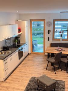a kitchen with a table and a dining room at APART six-o-nine in Schwendau
