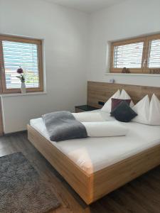 a bedroom with a large wooden bed with pillows at APART six-o-nine in Schwendau +11 photos