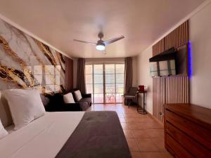 a bedroom with a bed and a living room at cœur d hibiscus P&V in Sainte-Luce +49 photos