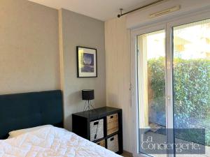 een slaapkamer met een bed en een glazen schuifdeur bij L'Atelier 6 - Poitiers in Mignaloux-Beauvoir