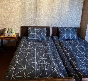 a bed with blue and white sheets and pillows at Hostel Ozurgeti in Ozurgetʼi