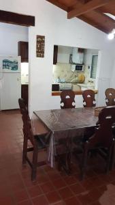 a kitchen with a table and chairs and a refrigerator at Casaquinta en Paso con Pileta y Parrilla in Paso de la Patria +10 photos