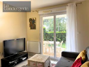 een woonkamer met een bank en een televisie bij L'Atelier 6 - Poitiers in Mignaloux-Beauvoir