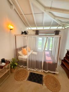 a room with a canopy bed with a window at Emma's Sea View in Hiriketiya