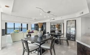 a living room with a table and chairs and a couch at Oceanfront Three-Bedroom Condo with Panoramic View in South Palm Beach