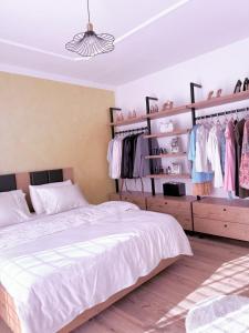 a bedroom with a bed and shelves of clothes at Swiss Villa Qerret in Golem