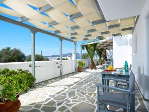 a patio with a blue table on a white wall at Galanis Rooms in Adamas