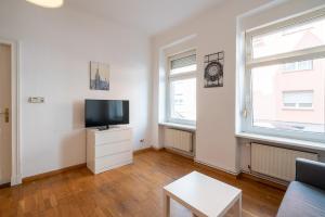 a living room with a flat screen tv and two windows at Apt Silizium 3 Zimmer Monteurwohnung zentral in Fürstenwalde +8 photos