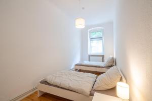 a small bedroom with two beds and a window at Apt Silizium 3 Zimmer Monteurwohnung zentral in Fürstenwalde