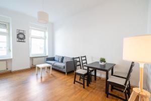 a living room with a couch and a table and chairs at Apt Silizium 3 Zimmer Monteurwohnung zentral in Fürstenwalde