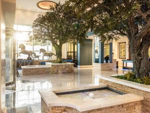 a lobby with a fountain with two statues of horses at Fairmont Austin in Austin