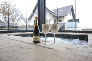a bottle of champagne and two wine glasses on a table at Pensiunea Giulia in Turda