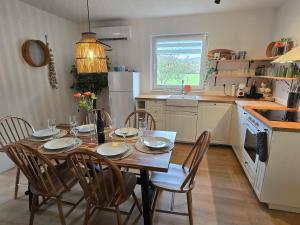 a kitchen with a wooden table with chairs and a dining room at Kuća za odmor Brlog in Brlog