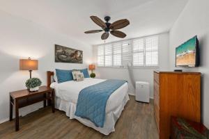Un dormitorio con una cama y un ventilador de techo. en Milowai 302 · MIL 302 Oceanfront 2BD w Ocean Views Whale Watch, en Wailuku
