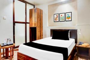 1 dormitorio con 1 cama blanca y algunas ventanas en Collection O Viman Nagar Downtown Formerly Hotel Cilantro, en Pune 30 fotos más
