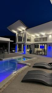 a large house with a swimming pool at night at Unit with bed in Busy Osu in Accra