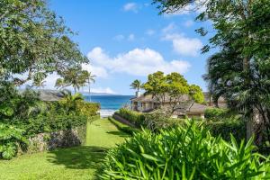 a house on the beach with the ocean in the background at Kapalua Ridge Villas 1423 in Kahana
