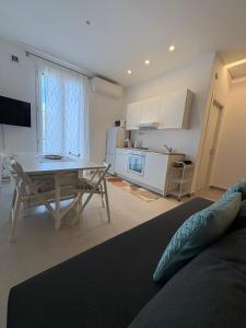 a living room with a table and a kitchen at La Nassa e il Faro in Porticello +2 photos