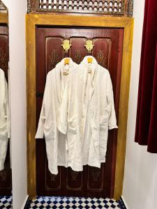 a wooden door with white shirts hanging on it at Riad Dar Laura in Fès