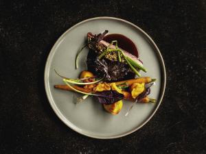 a plate of food with vegetables on a table at Mercure Han-sur-Lesse in Han-sur-Lesse
