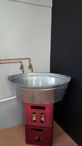 a metal sink in the corner of a room at The Backpack Shack in Mossel Bay