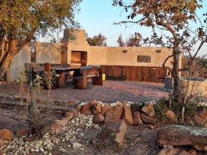 a house with a picnic table in front of it at Twenty Four Mabalingwe Nature Reserve in Warmbaths