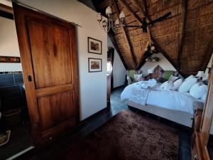 a bedroom with a bed and a wooden door at Twenty Four Mabalingwe Nature Reserve in Warmbaths