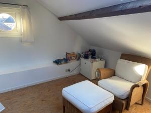 Pont-à-CellesにあるLe pigeonnier des voyageurs Le pigeonnier des voyageurs aéroport Charleroiのリビングルーム(椅子、スツール付) +1枚の写真