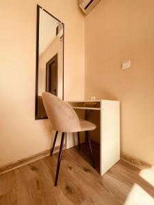 ein Stuhl neben einem Schreibtisch mit einem Spiegel in der Unterkunft Relax Family ApartHotel - Signature Residence in Ouarzazate