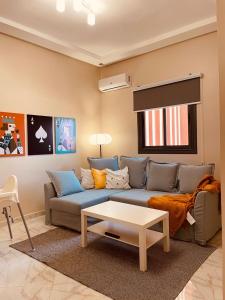 ein Wohnzimmer mit Sofa und Tisch in der Unterkunft Relax Family ApartHotel - Signature Residence in Ouarzazate