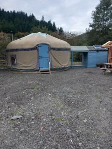 a large tent with a blue door in a yard at Hillside Retreats in Machynlleth