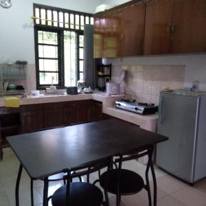 a kitchen with a table and a refrigerator at Villa Montana 2 in Cicadas +4 photos