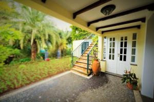 a porch of a house with a white door and stairs at Casa da Portada in São Vicente