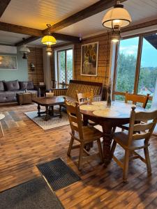 a living room with a wooden table and chairs at Piliakalnio Apartmentai in Kupiškis