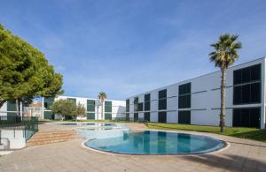 a building with a swimming pool in front of a building at Stupendo Appartamento a Cala’n Bosch Minorca in Cala'n Bosch