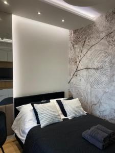 a bedroom with a black bed with a wall at Chillout Luxury Touch Apartment - Free Parking Wola Tower in Warsaw