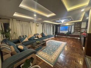 a living room with blue couches and a television at My Stay Nepal in Kathmandu