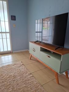a living room with a tv on a dresser at Casa Ribeiro in Canguçu