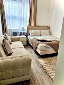 ein Schlafzimmer mit einem Bett und einer Couch und einem Fenster in der Unterkunft Luxury Apartment with Grand Living Space London in London