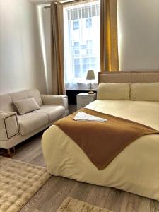 ein Schlafzimmer mit einem großen Bett und einer Couch in der Unterkunft Luxury Apartment with Grand Living Space London in London