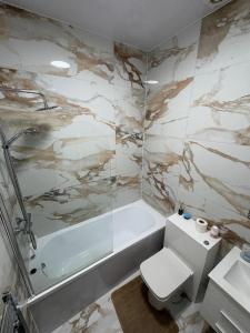 ein Badezimmer mit Badewanne, Toilette und Waschbecken in der Unterkunft Luxury Apartment with Grand Living Space London in London