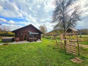 a log cabin with a playground in the yard at Kuća za odmor Brlog in Brlog