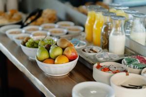 a buffet with bowls of fruit and bottles of milk at Ibis Puerto General San Martin in Aldao