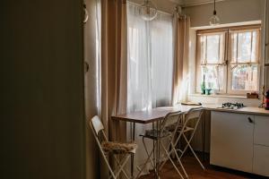 a kitchen with a table and chairs and a window at Stone House in Târgu Secuiesc