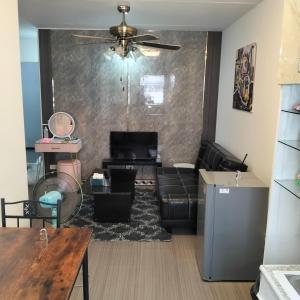 a living room with a couch and a table at อิมแพ็ค popular condo c5 แม่ตังค์ in Ban Bang Phang