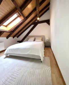 a bedroom with a white bed and wooden ceilings at appartement confortable en centre ville in Montreux