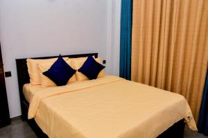 a bedroom with a bed with blue pillows at Urban Nest Apartment 