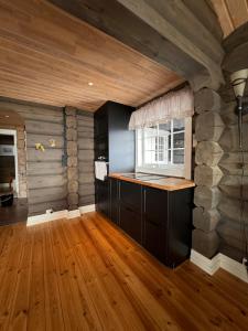 cocina con suelo de madera y pared de piedra en Dyrøy Holiday - Lodge with Jacuzzi, en Nordhus 16 fotos más