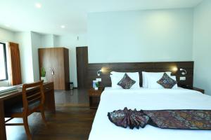 Una habitación de hotel con una cama y un escritorio y una cama. en DEWALING by Laughing Lama Hotels, en Phuntsholing 21 fotos más